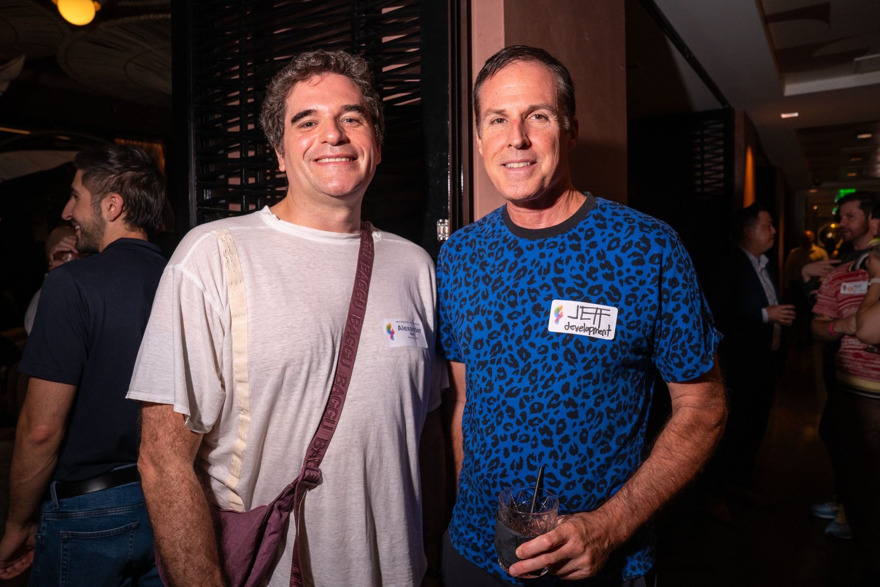 Two attendees smiling together in the lounge with name tags on
