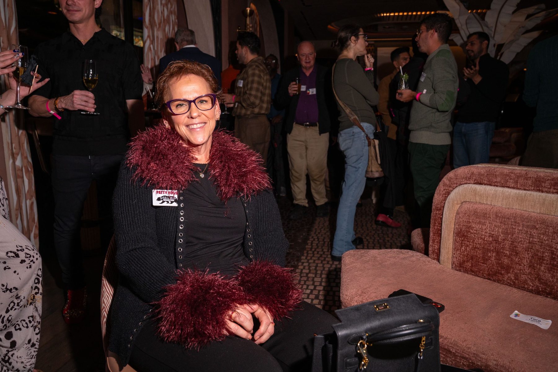 An attendee seated in a velvet armchair in the lounge