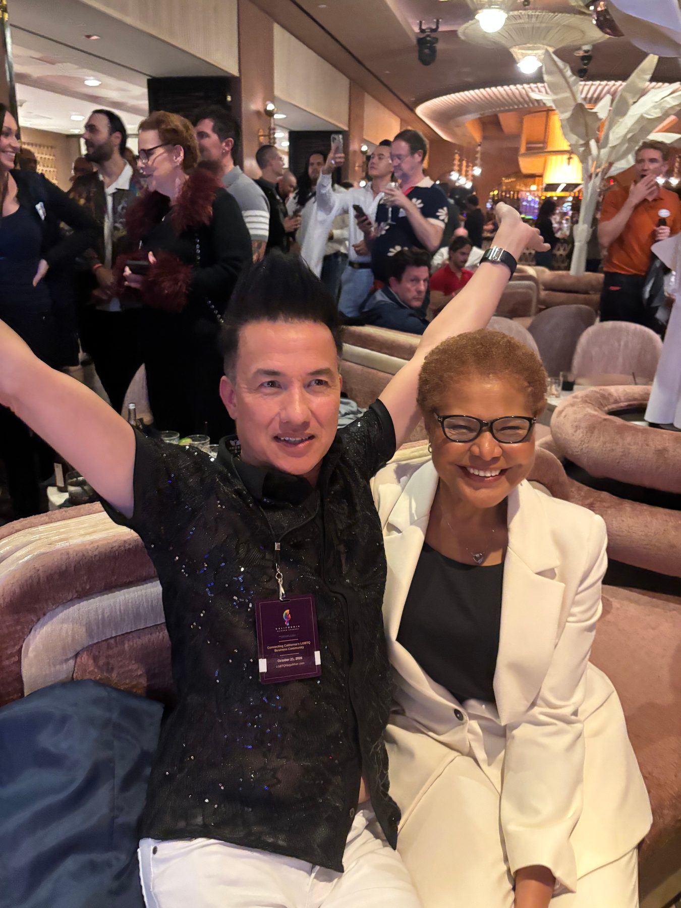 Two attendees celebrating on a curved velvet banquette